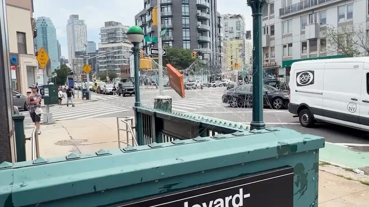A webbed Spider-Man pizza box hanging over a New York intersection